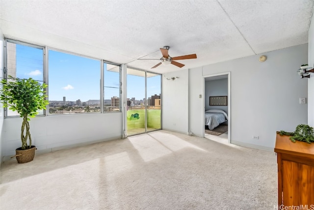 unfurnished sunroom with ceiling fan