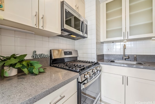 kitchen featuring white cabinets, decorative backsplash, sink, and appliances with stainless steel finishes