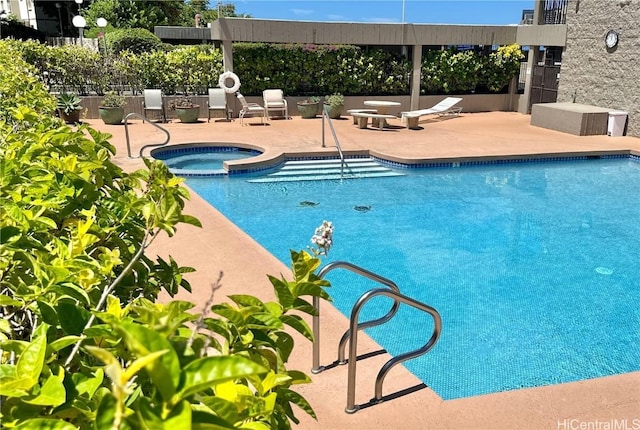 view of pool with a patio and an in ground hot tub