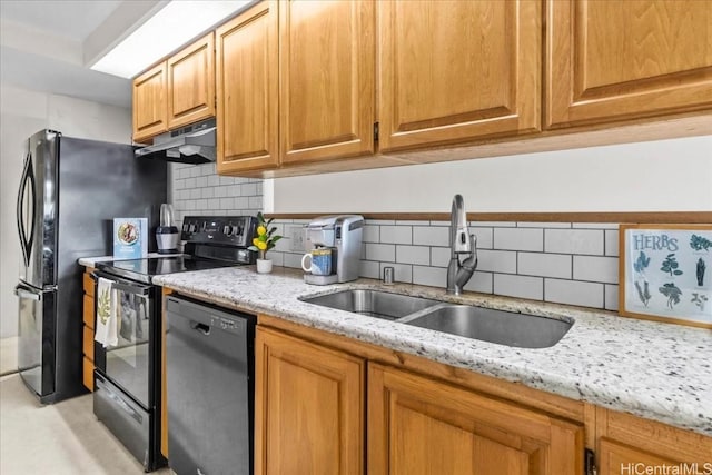 kitchen featuring sink, backsplash, light stone counters, and black appliances