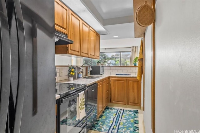 kitchen with dishwashing machine, exhaust hood, electric stove, sink, and black fridge