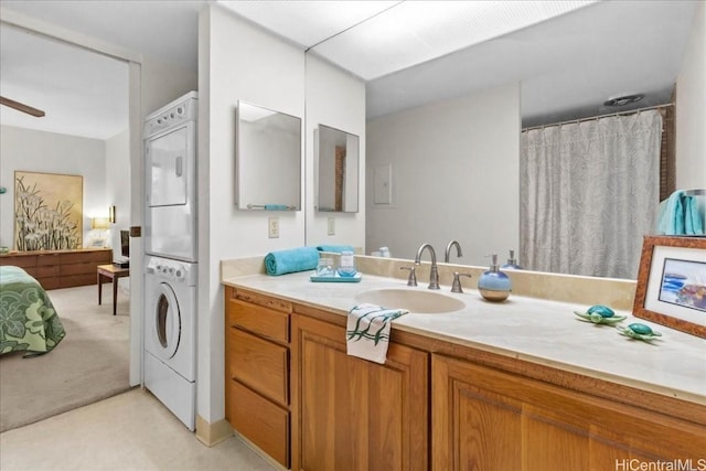 bathroom with ceiling fan, vanity, and stacked washer and clothes dryer