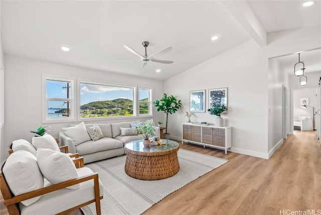 living room with lofted ceiling with beams, ceiling fan, and light wood-type flooring