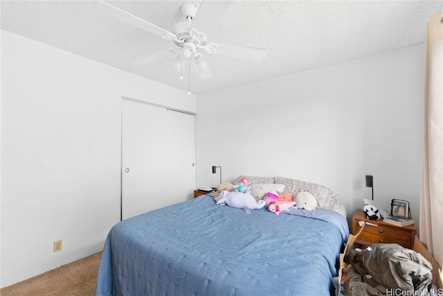 carpeted bedroom with ceiling fan and a textured ceiling