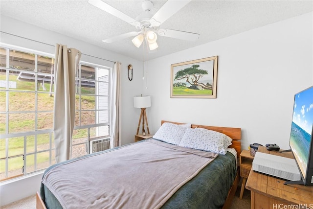 carpeted bedroom with ceiling fan and a textured ceiling