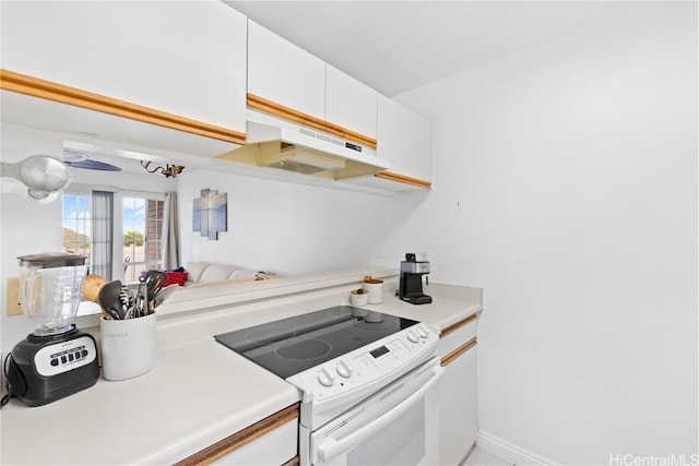 kitchen featuring white cabinetry, white range with electric cooktop, and range hood