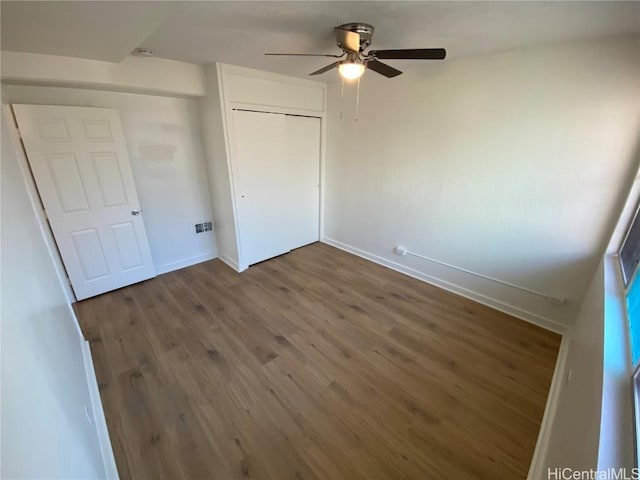 unfurnished bedroom with ceiling fan, dark hardwood / wood-style flooring, and a closet