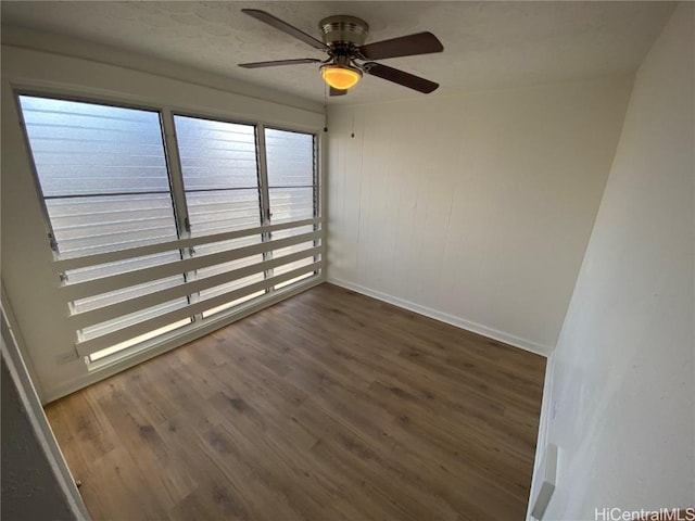 spare room with dark hardwood / wood-style floors and ceiling fan