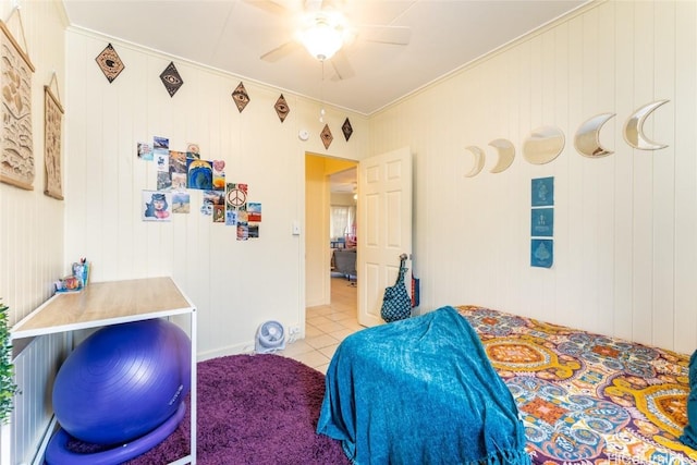 tiled bedroom with ceiling fan, crown molding, and wood walls