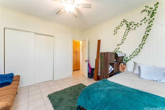 bedroom with a closet, ceiling fan, crown molding, and light tile patterned flooring