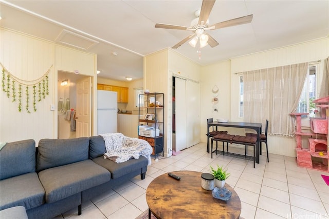 tiled living room with ceiling fan and ornamental molding