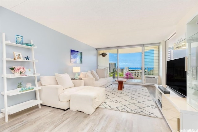 living room with light hardwood / wood-style flooring, a wall of windows, and cooling unit