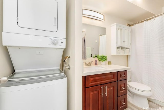 bathroom featuring vanity, toilet, and stacked washing maching and dryer