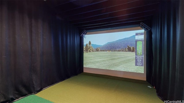 recreation room with carpet flooring, a mountain view, and golf simulator