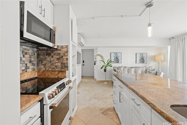 kitchen featuring white cabinets, decorative light fixtures, high end stove, and a wall unit AC