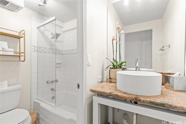 full bathroom with tiled shower / bath combo, toilet, and vanity