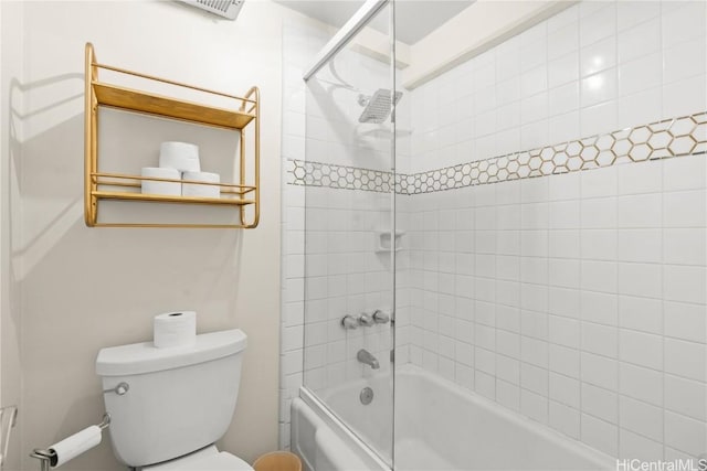 bathroom featuring tiled shower / bath combo and toilet