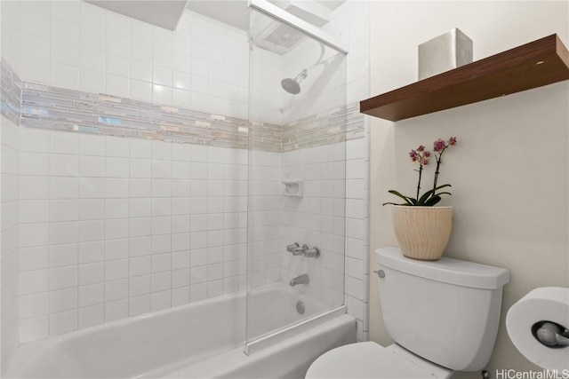 bathroom with tiled shower / bath combo and toilet