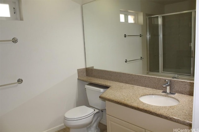 bathroom with an enclosed shower, vanity, and toilet