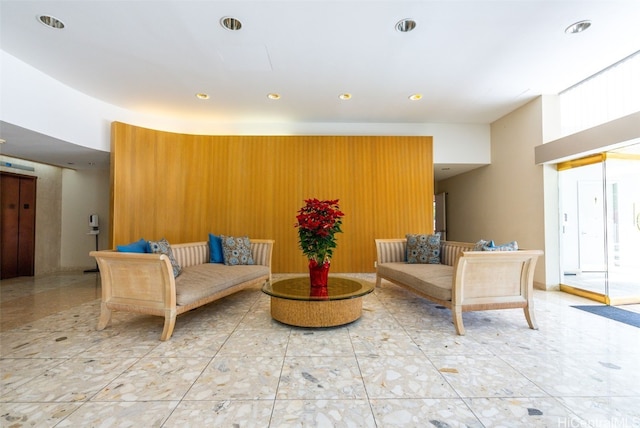 living room with elevator and wooden walls