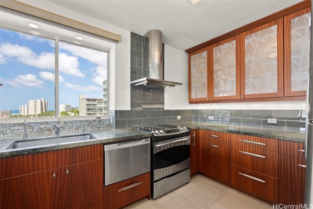 kitchen featuring appliances with stainless steel finishes, tasteful backsplash, sink, wall chimney range hood, and light tile patterned floors