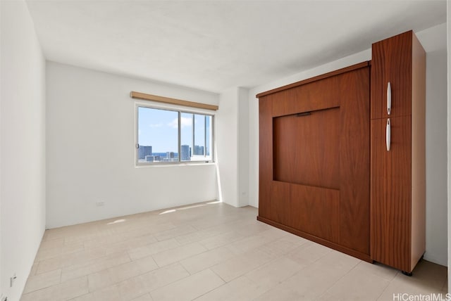 unfurnished bedroom featuring a closet and light tile patterned floors