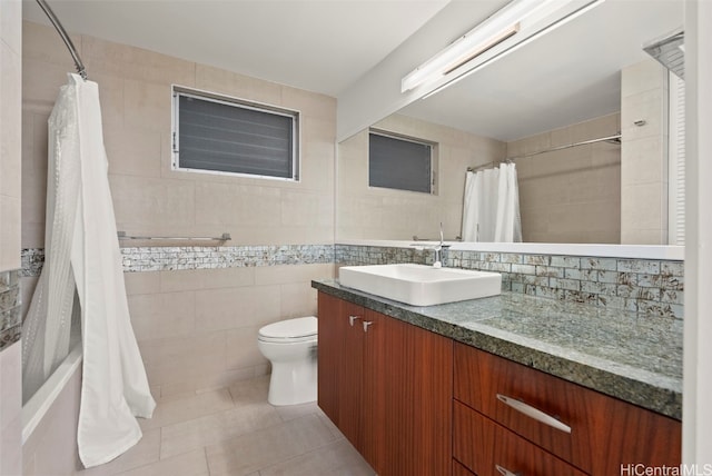 bathroom with tile patterned floors, backsplash, toilet, vanity, and tile walls