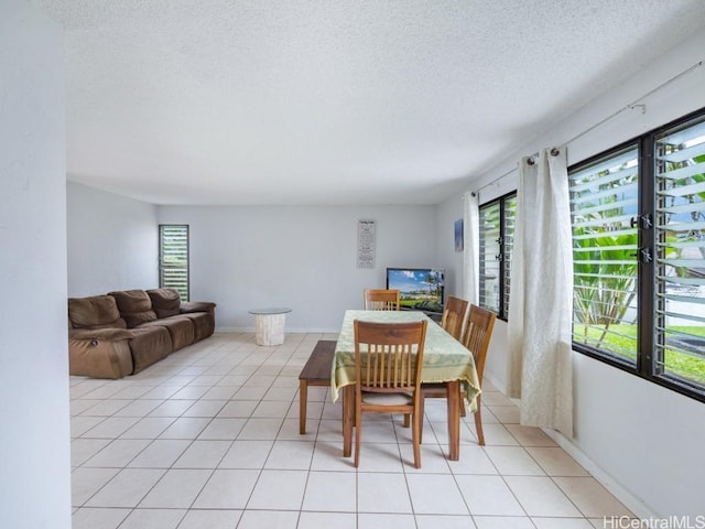 dining area with light tile patterned floors and a textured ceiling