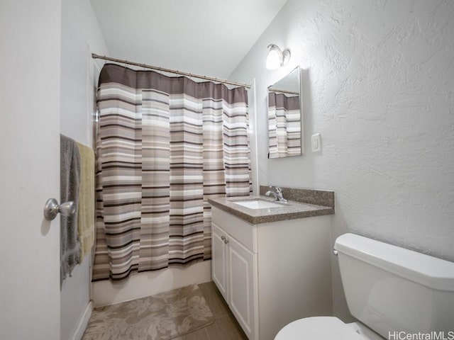 full bathroom with vanity, vaulted ceiling, shower / bath combo with shower curtain, tile patterned flooring, and toilet