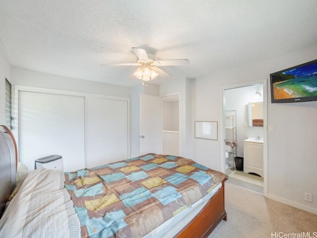 bedroom with a textured ceiling, connected bathroom, a closet, and ceiling fan