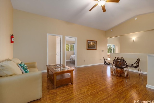 living room with ceiling fan, vaulted ceiling, and hardwood / wood-style flooring