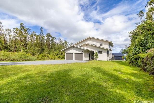 view of front of home with a front yard and a garage