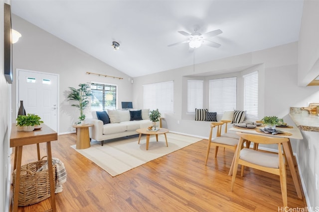 living room with ceiling fan, light wood-type flooring, and vaulted ceiling