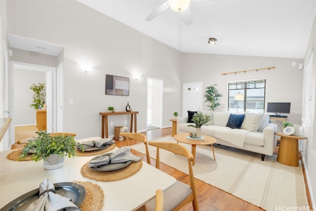 living room featuring light hardwood / wood-style floors, vaulted ceiling, and ceiling fan