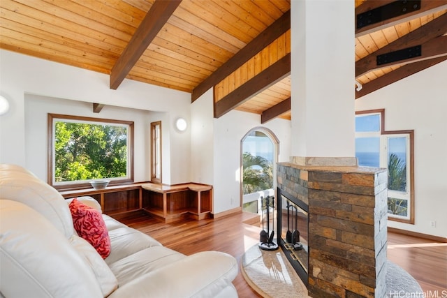 living room with vaulted ceiling with beams, a healthy amount of sunlight, light wood-type flooring, and wooden ceiling