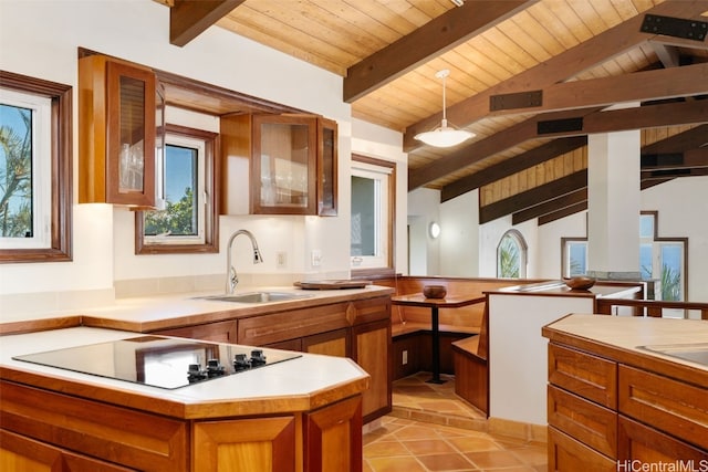 kitchen featuring sink, vaulted ceiling with beams, decorative light fixtures, black electric stovetop, and wood ceiling