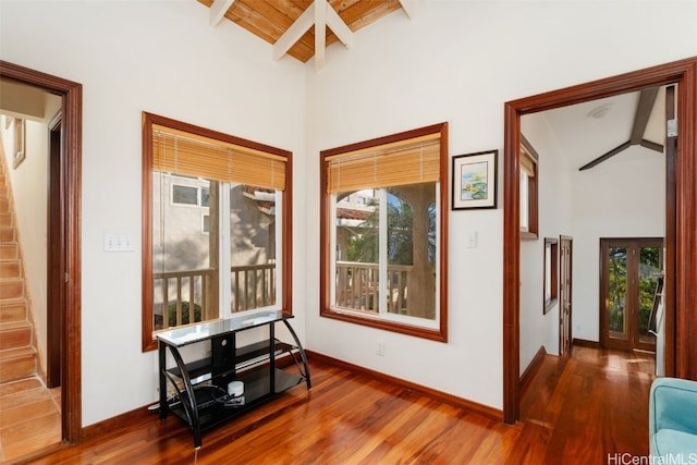 hall featuring beamed ceiling, hardwood / wood-style flooring, high vaulted ceiling, and wooden ceiling