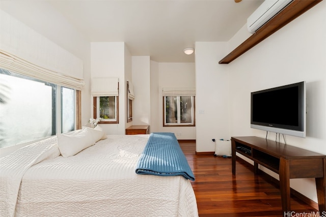 bedroom with a wall mounted AC and dark wood-type flooring