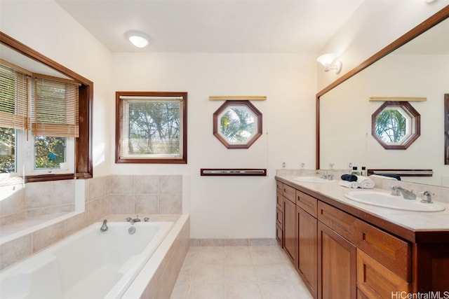 bathroom featuring tile patterned floors, tiled bath, vanity, and a healthy amount of sunlight