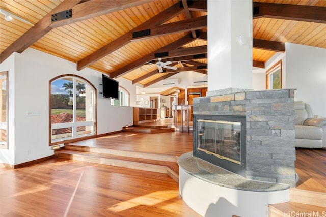 living room with beam ceiling, a stone fireplace, wooden ceiling, and hardwood / wood-style flooring