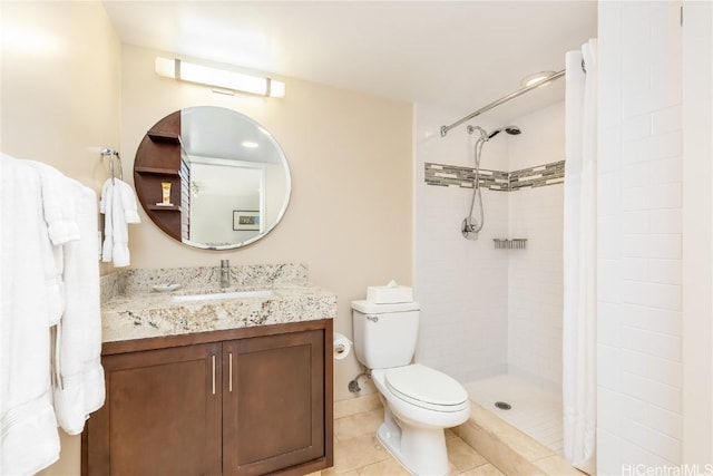 bathroom featuring toilet, a tile shower, vanity, and tile patterned floors