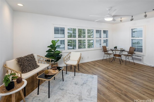 living area featuring hardwood / wood-style floors and ceiling fan