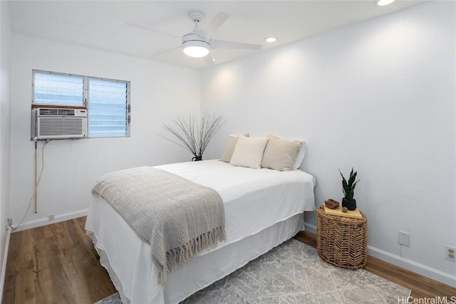 bedroom with hardwood / wood-style flooring, ceiling fan, and cooling unit