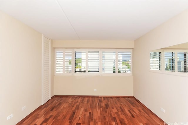 unfurnished room with dark wood-type flooring