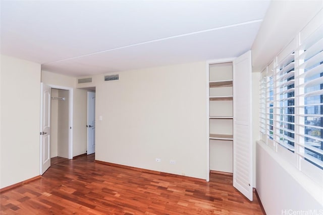 unfurnished bedroom with dark hardwood / wood-style flooring