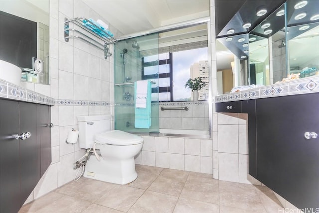 full bathroom with vanity, tile patterned flooring, toilet, enclosed tub / shower combo, and tile walls