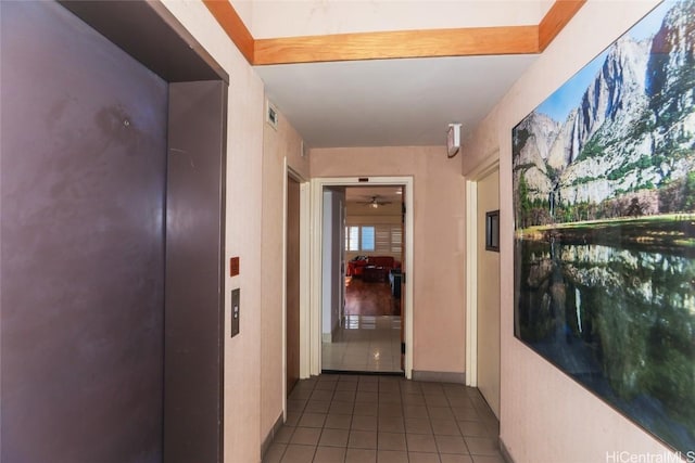 hall featuring dark tile patterned flooring and elevator