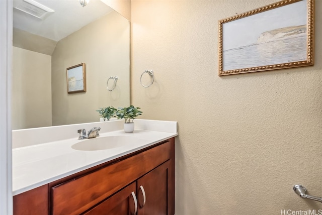 bathroom with vanity and lofted ceiling