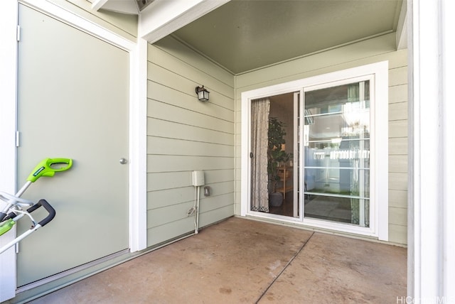 view of exterior entry with a patio area