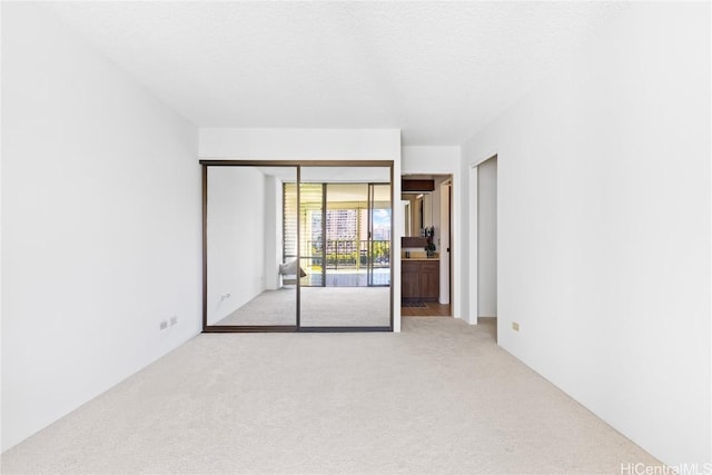 carpeted spare room featuring a textured ceiling